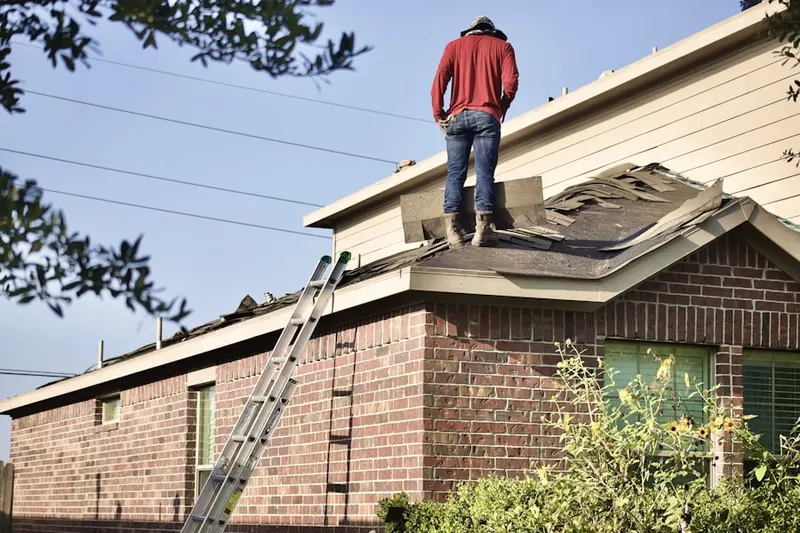 Professional roofer working on a residential roof in Reed Park